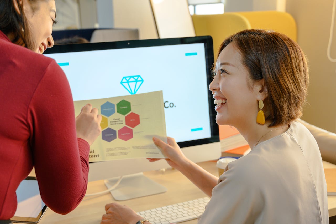 Woman in White Shirt Showing a Visual Content to a Woman in Red Long Sleeve Shirt